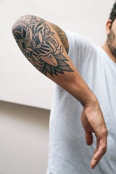 a man with a tattoo on his arm pointing at the viewer's phone screen