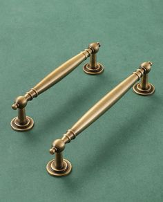 two antique style brass door handles on green background