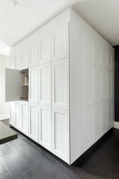 an empty kitchen with white cabinets and black counter tops in the center of the room