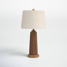 a lamp that is sitting on top of a table with a white shade over it