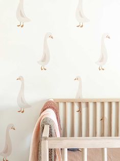 a baby's room with a crib and wall decals