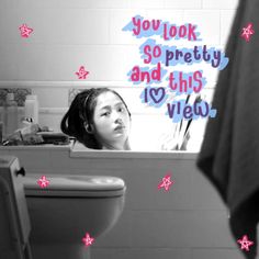 a girl is looking at herself in the mirror while brushing her teeth with pink stars