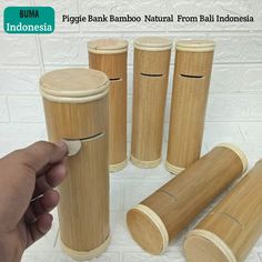 a hand is pointing at bamboo tube holders