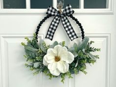 a white door with a black and white wreath hanging on it