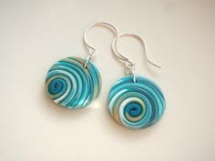 a pair of earrings with blue and green swirls