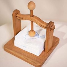 a small wooden dollhouse bed with white sheets