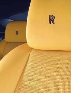 the interior of a yellow sports car with black lettering on it's seat covers