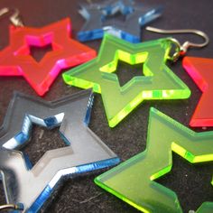 "A throwback to a time of Big Hair and Big Style - These Neon Star Earrings Catches Eyes and Glows in Black light! ★ YOU PICK which neon color you like best! All Big Star Cutout Earrings are made of laser cut neon pink, green OR blue acrylic. ★ Surprisingly lightweight, each Radiant Star Pendant measures 1.25\" wide and hangs on your choice of earring hooks! Pick from: ~ Nickel Free (Shown in Pictures) ~ Stainless Steel ~ Plastic Hooks ~ Clip Ons ~ Titanium Hooks ★ These Cutout Star Earrings mak Rave Jewelry, 80s Neon, Earrings Star, Neon Color, Neon Blue, Big Star, Star Pendant, Star Earrings, Black Light