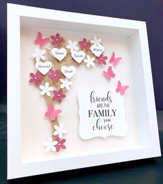 a white frame with some pink and white paper flowers in the shape of hearts on it