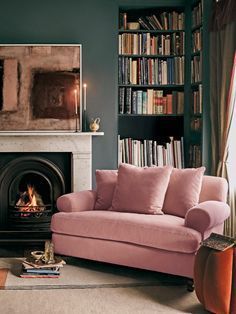 a living room filled with furniture and a fire place in front of a book shelf