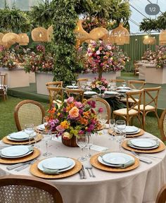 a table set up with plates and place settings for an outdoor dinner in the garden