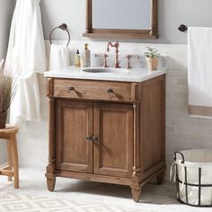 a bathroom with a sink, mirror and towel rack on the wall next to it