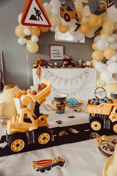 a birthday party with construction vehicles and balloons