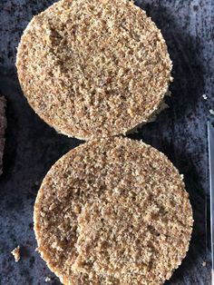 two hamburger patties sitting on top of a counter next to a knife and fork