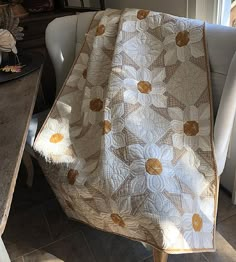 a white chair sitting next to a table covered in a blanket