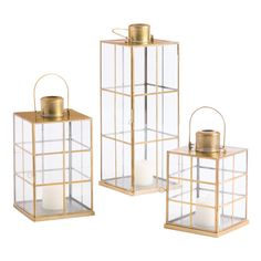 three gold lanterns with candles inside them