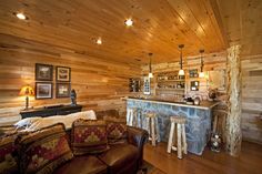 a living room filled with furniture next to a bar