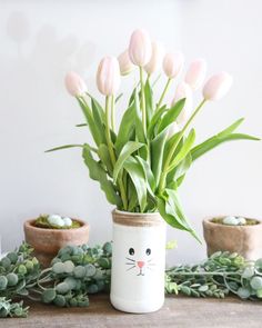 a vase with flowers in it sitting on a table next to succulents