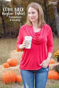 a woman standing in front of pumpkins holding a cup