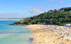 many people are on the beach and in the water