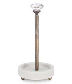 a white and gold pedestal with a diamond on it's top, in front of a white background