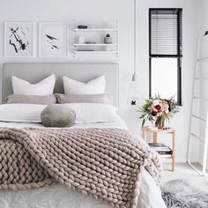 a bed with white sheets and blankets on it