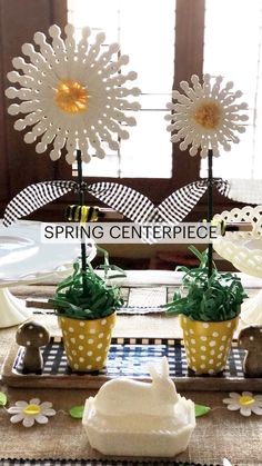 cupcakes with green frosting and white flowers are on a tray in front of a window