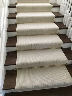 a set of stairs with carpeted treads and wooden handrails in a home