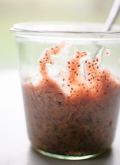 a glass jar filled with food sitting on top of a table next to a spoon