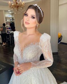 a woman in a wedding dress posing for the camera with her hand on her hip