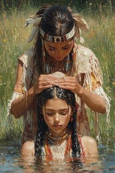 two native american girls washing their heads in the water, with grass and wildflowers behind them