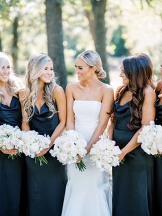 a group of women standing next to each other holding bouquets