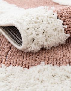 a close up of a rug with a white and pink design on the bottom half