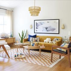 a living room filled with furniture and a painting on the wall above it's windows