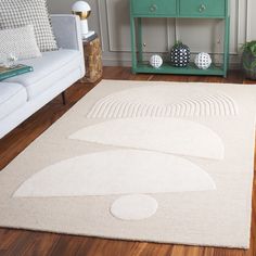 a living room with a white rug and green cabinet next to it on a hard wood floor