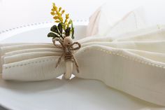 a white plate topped with a bow tie and yellow flowers on it's side