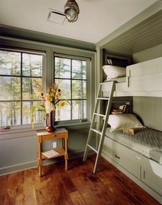 a room with bunk beds and a ladder next to a window that has flowers on it