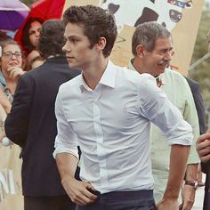 a man in white shirt and black pants standing next to other people