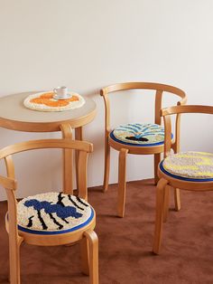 three wooden chairs sitting next to each other on top of a brown carpeted floor