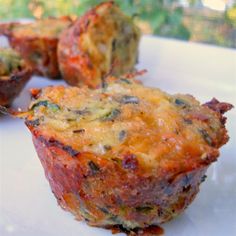 two muffins on a plate with the words zucchini tots above them