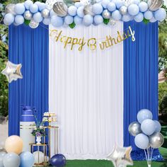 a blue and white birthday party setup with balloons, streamers, cake and decorations