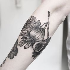 a black and white photo of an onion tattoo on the arm