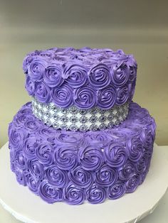 two tiered cake with purple icing roses on top