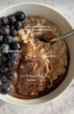 a bowl filled with oatmeal and blueberries on top of a table