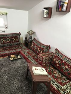 a living room with couches and rugs on the floor in front of a window