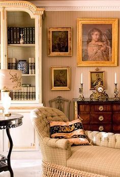 a living room filled with furniture and pictures on the wall above it's bookshelf