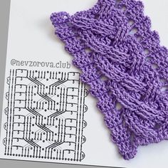 a purple crochet piece is laying on top of a card