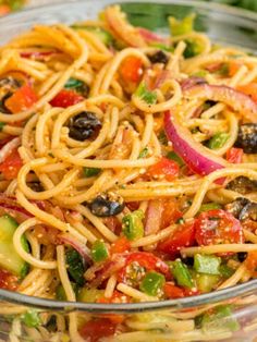 a glass bowl filled with pasta and vegetables