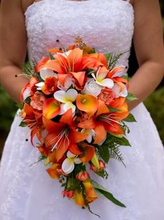 a bride holding a bouquet of orange and white flowers