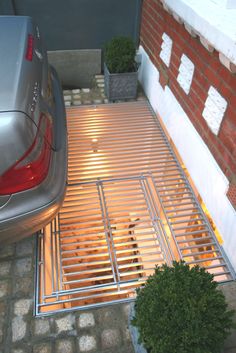 a car parked next to a brick building with metal grates on it's sides